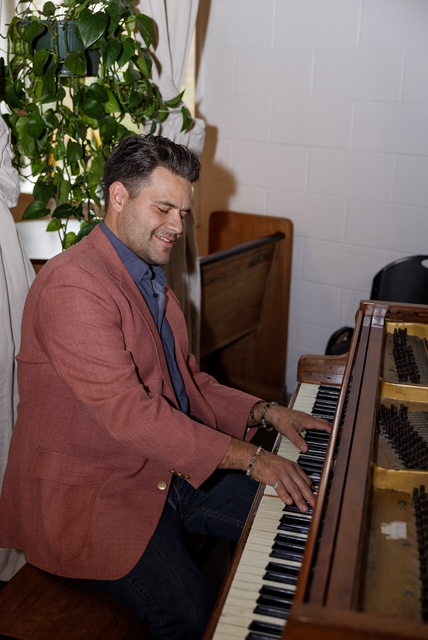 Curtis McLeod performing piano during an event in a bright room